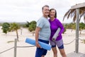 Portrait of cheerful caucasian senior couple with exercise mats posing at tourist resort, copy space Royalty Free Stock Photo