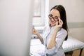 Portrait of cheerful Caucasian woman ultrasound specialist, holding ultrasound sensor of modern ultrasonic scanner