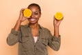 Portrait of cheerful charming person hold two half orange cover eye isolated on beige color background Royalty Free Stock Photo