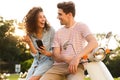 Portrait of man and woman wearing earphones listening to music while sitting on motorbike together on city street Royalty Free Stock Photo