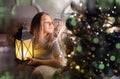 Portrait of a cheerful cute girl near a Christmas tree with a lantern. New Year holidays Royalty Free Stock Photo