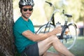 portrait cheerful cyclist resting under tree