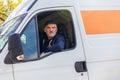 Delivery driver looking out the window of the white cargo van vehicle, delivering goods by car Royalty Free Stock Photo