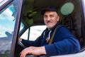 Cheerful delivery driver looking out the window of the white cargo van vehicle, delivering goods by car Royalty Free Stock Photo