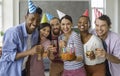 Portrait of cheerful diverse young friends celebrating birthday together at home. Royalty Free Stock Photo