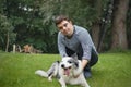 Portrait of cheerful down syndrome adult man playing with dog outdoors in backyard. Royalty Free Stock Photo