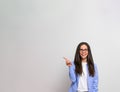 Portrait of cheerful female entrepreneur pointing towards copy space while standing  on background. Businesswoman smiling Royalty Free Stock Photo