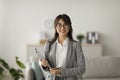 Portrait of cheerful female psychologist posing with clipboard, looking and smiling at camera, working in modern office Royalty Free Stock Photo