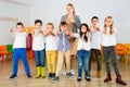 Portrait of cheerful female teacher with her happy schoolkids in classrom Royalty Free Stock Photo