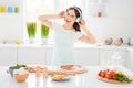 Portrait of cheerful funky girl enjoy cooking pizza while listen rhythm melody music have wireless headset wear dotted Royalty Free Stock Photo