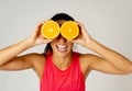 Portrait of cheerful funny and attractive woman holding sliced orange over her eyes Royalty Free Stock Photo