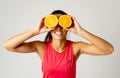 Portrait of cheerful funny and attractive woman holding sliced orange over her eyes Royalty Free Stock Photo