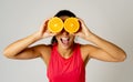 Portrait of cheerful funny and attractive woman holding sliced orange over her eyes Royalty Free Stock Photo