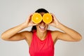 Portrait of cheerful funny and attractive woman holding sliced orange over her eyes Royalty Free Stock Photo