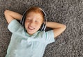 Portrait of cheerful ginger boy with wireless headset Royalty Free Stock Photo