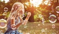 Portrait of a cheerful girl blowing soap bubbles