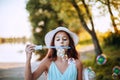 Portrait of a cheerful girl blowing soap bubbles. Happy child  plays outdoors in nature Royalty Free Stock Photo