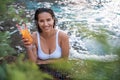 Glad female tasting liquid in swimming pool Royalty Free Stock Photo