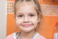 Portrait of a cheerful girl with a face stained with flour