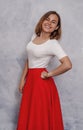 Portrait of a cheerful girl, smiling ironically. Red skirt Royalty Free Stock Photo