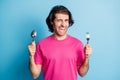 Portrait of cheerful guy holding in hands fork spoon winking healthy snack lunch expect isolated over bright blue color