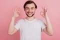 Portrait of cheerful handsome guy raise hand show okey gesture toothy smile on pink background Royalty Free Stock Photo