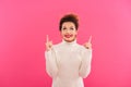 Portrait of a cheerful happy girl pointing two fingers up Royalty Free Stock Photo