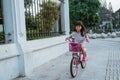 A portrait of a cheerful and happy little girl playing a bicycle in the park Royalty Free Stock Photo