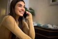 Portrait of cheerful happy pretty young woman talking on phone holding smartphone close to ear. Smiling adult girl using her Royalty Free Stock Photo