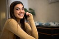 Portrait of cheerful happy pretty young woman talking on phone holding smartphone close to ear. Smiling adult girl using her Royalty Free Stock Photo