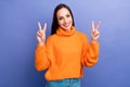 Portrait of cheerful happy woman wearing orange pullover showing double v sign promoting psychotherapy isolated on