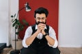 Portrait of cheerful Indian businessman wearing elegant formalwear sitting on chair and smiling looking at camera. Front Royalty Free Stock Photo