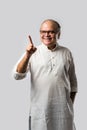 Portrait of cheerful Indian senior old man pointing or presenting or in hands folded pose