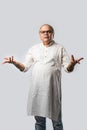 Portrait of cheerful Indian senior old man pointing or presenting or in hands folded pose Royalty Free Stock Photo