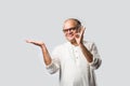 Portrait of cheerful Indian senior old man pointing or presenting or in hands folded pose Royalty Free Stock Photo