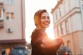 Portrait of a cheerful joyful beautiful young woman with a cute smile in fashionable black clothes outdoors in the city Royalty Free Stock Photo