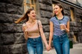 Portrait of cheerful ladies with red lips stick laughing wearing striped t-shirt denim jeans rucksack bagpack in city