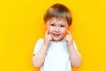 Portrait of cheerful little boy child three years old, standing isolated over yellow background. Looking camera. showing white Royalty Free Stock Photo