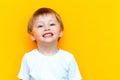 Portrait of cheerful little boy child three years old, standing isolated over yellow background. Looking camera. showing white Royalty Free Stock Photo