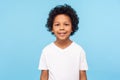 Portrait of cheerful little boy with curly hair in T-shirt smiling funny and carefree, showing two front teeth, healthy happy Royalty Free Stock Photo
