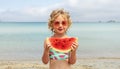 Portrait little girl licking fresh watermelon slice posing on beach having fun and positive emotion Royalty Free Stock Photo