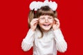 Portrait of cheerful little girl in very big glasses and white bow. Concept of eyesight or teaching