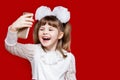 Portrait of cheerful little girl in very big glasses and white bow. Concept of eyesight or teaching