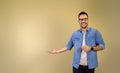 Portrait of cheerful male entrepreneur gesturing towards copy space while standing isolated on beige background. Happy businessman Royalty Free Stock Photo