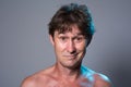 Portrait of a cheerful man with a naked torso on a gray background Royalty Free Stock Photo