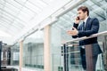 Business man walking while talking on mobile phone on his way to work Royalty Free Stock Photo