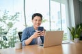 Portrait of a cheerful man using smart phone at home office Royalty Free Stock Photo