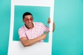 Portrait of cheerful man wear print t-shirt in sunglass directing at sale empty space from frame isolated on turquoise Royalty Free Stock Photo