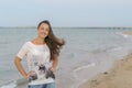 Portrait of a cheerful middle aged woman standing at the sea. Attractive and happy middle aged woman walking along the seashore Royalty Free Stock Photo