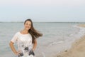 Portrait of a cheerful middle aged woman standing at the sea. Attractive and happy middle aged woman walking along the seashore Royalty Free Stock Photo